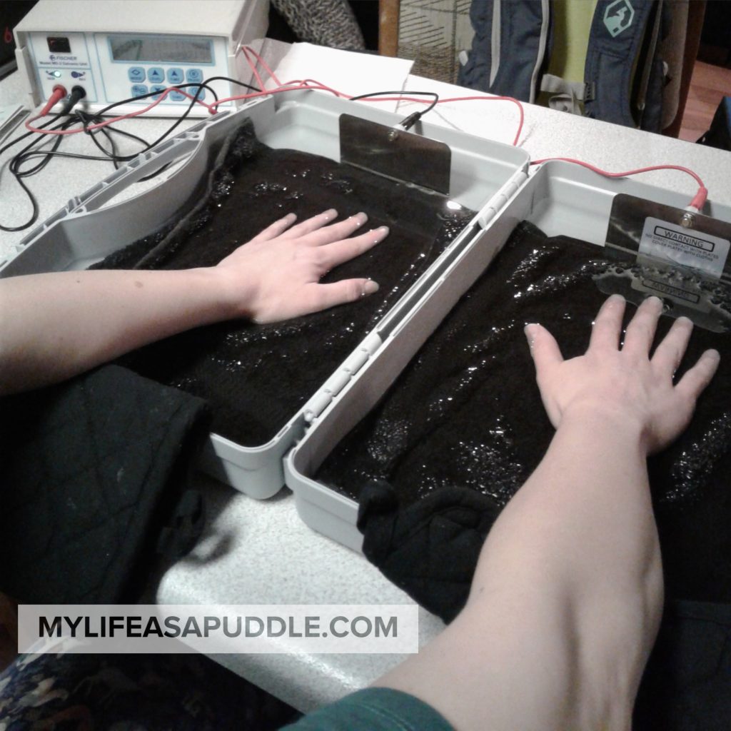 woman with hands in a tray of water